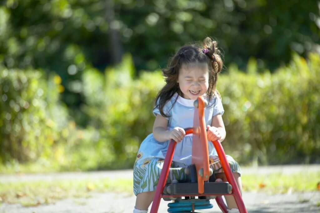 女の子が公園の遊具で遊んでいる様子