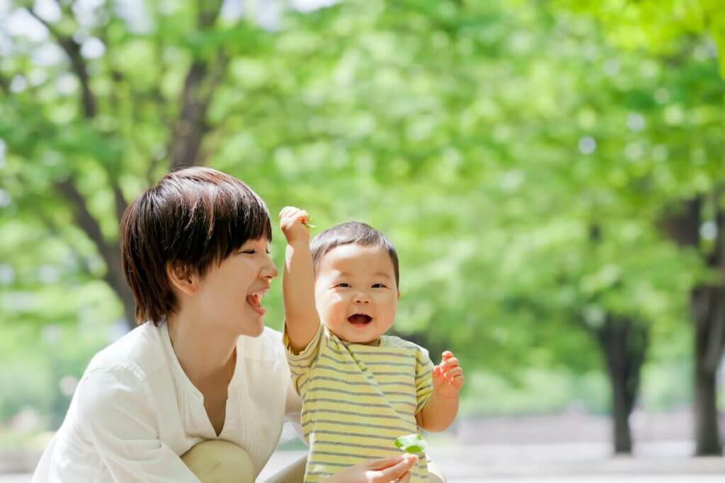 公園で母親と遊ぶ小さな男の子