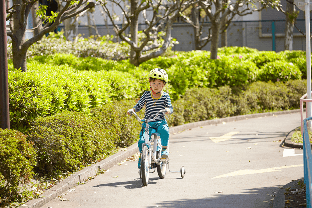 補助輪つき自転車にのる子ども