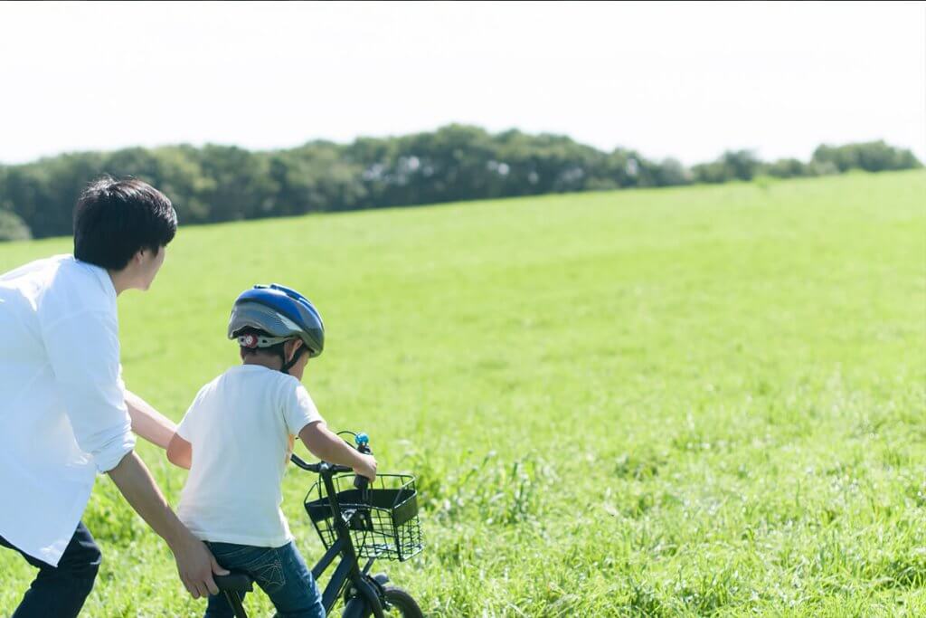 自転車に挑戦する男の子とパパ